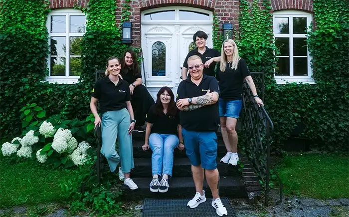 Das Haus von Pier Vier, davor eine Wiese mit zwei Bäumen